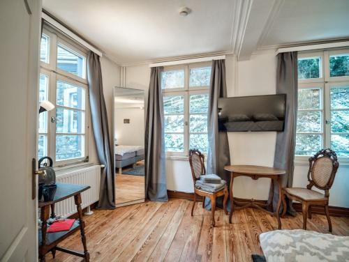 a living room with windows and a table and chairs at Haus Stehlings in Monschau