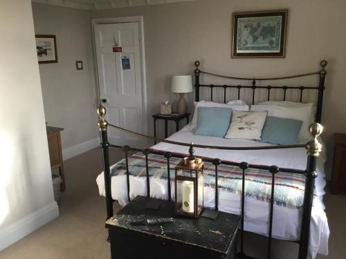 a bedroom with a bed with a clock on a table at Lee-Side B&B in Robin Hood's Bay