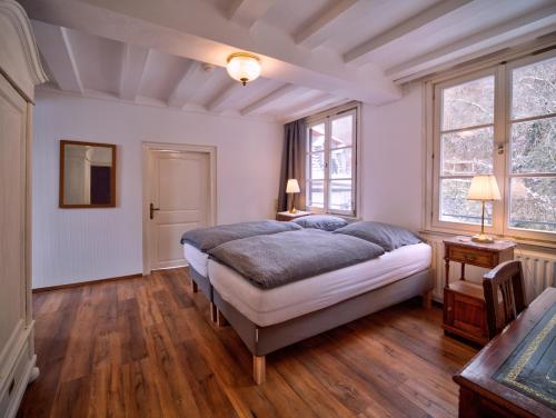 a bedroom with a large bed and two windows at Haus Stehlings in Monschau