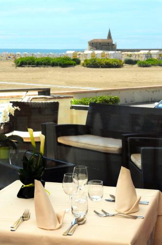 a table with glasses and napkins on top of a restaurant at Hotel Delfino in Caorle