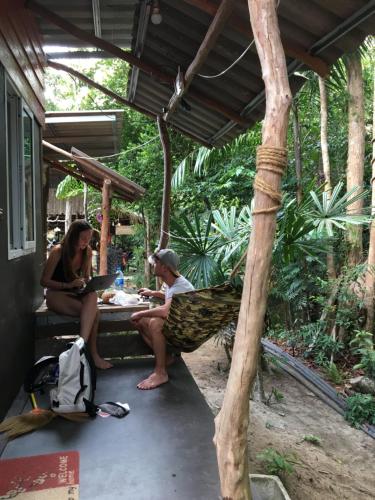 three people sitting in a hammock under a pergola at Freedom home in Ko Chang