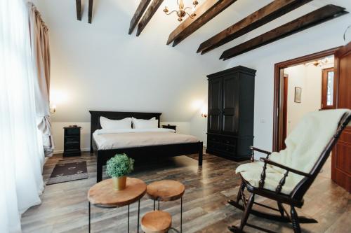 a bedroom with a bed and a chair and a table at Casuta Boema in Râşnov