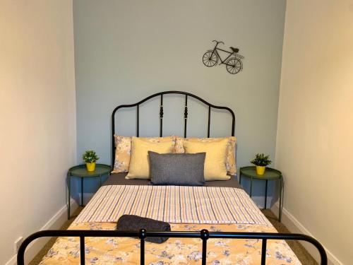 a bedroom with a bed with two tables and a bike on the wall at Gordon House - Kettering in Kettering