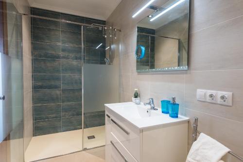 a bathroom with a shower and a sink and a mirror at Biali in Búger