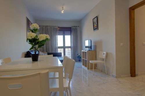 a dining room and living room with a table and chairs at Apartamentos Centro 1 El Puerto de Santa Maria in El Puerto de Santa María
