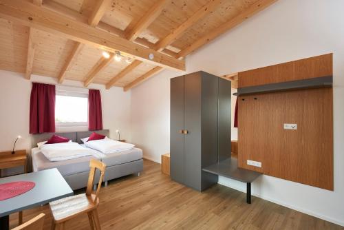 a bedroom with a bed and a desk and a table at Ferienwohnungen Weinstadt in Weinstadt