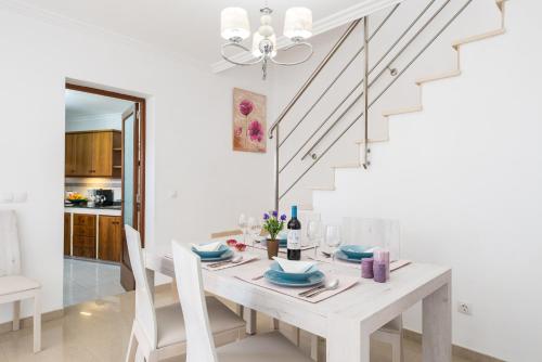 a white dining room with a white table and chairs at Biali in Búger