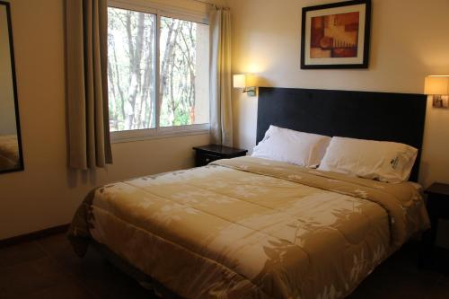 a bedroom with a large bed with a window at Entrepinos Apart in Mar Azul