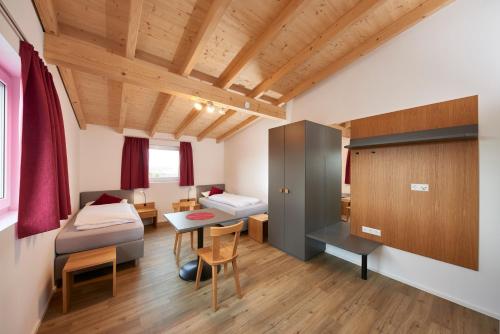 Zimmer mit 2 Betten und einem Tisch in einem Zimmer in der Unterkunft Ferienwohnungen Weinstadt in Weinstadt