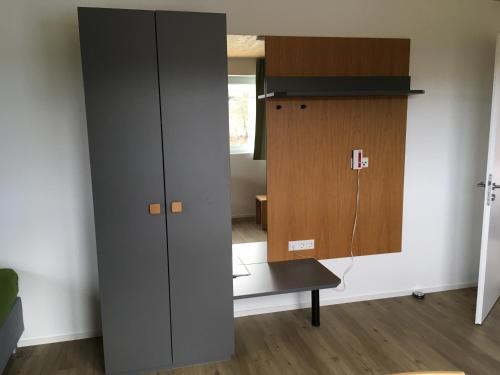 a large gray cabinet in a room with a table at Ferienwohnungen Weinstadt in Weinstadt