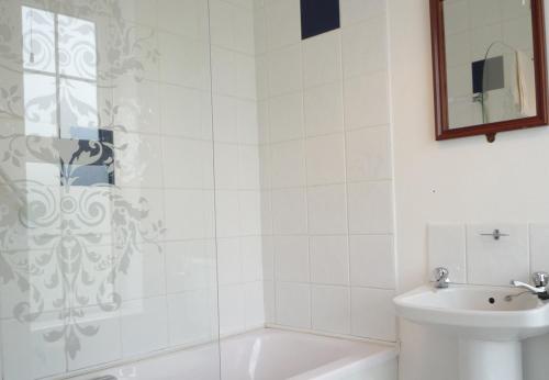 een badkamer met een douche, een wastafel en een toilet bij Ballybunion Holiday Homes No 27 in Ballybunion