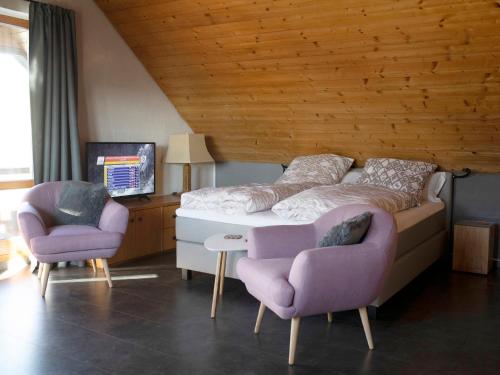 a bedroom with a bed and two chairs at Stolzing-Apart in Bayreuth