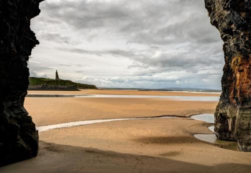 a view of the beach from a cave in the sand at Ballybunion Holiday Cottages No 27 by Trident Holiday Homes in Ballybunion