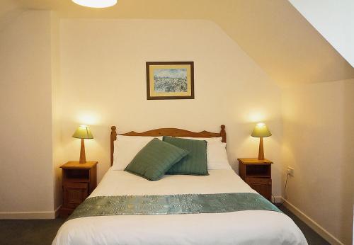 een slaapkamer met een bed met twee lampen aan beide zijden bij Ballybunion Holiday Homes No 27 in Ballybunion