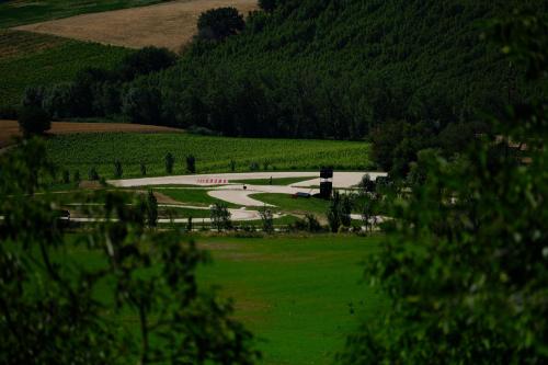 a view of a field with a farm in the distance at Casa Monteluro - B&b in Tavullia