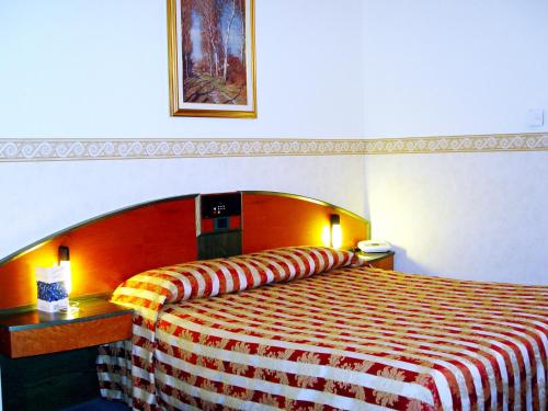 a hotel room with a bed with a striped blanket at Best Western Plus Soave Hotel in San Bonifacio