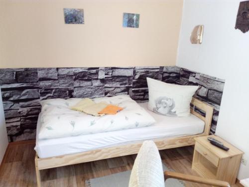 uma cama num quarto com uma parede de pedra em Am Mühlteich em Taltitz