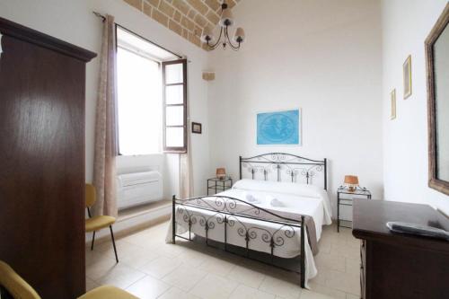 a white bedroom with a bed and a window at Camera vista mare Holidayz in Gallipoli