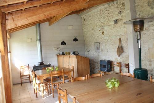 - une salle à manger avec une table et une cuisinière dans l'établissement Gîtes Grand Pré ! et la Roulotte de Roquecor, à Roquecor
