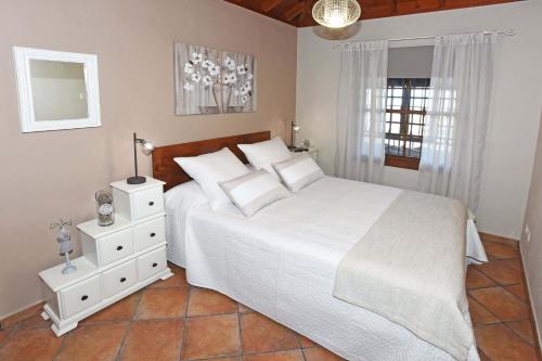 Un dormitorio con una gran cama blanca y una ventana en Casa Maday, en Mazo