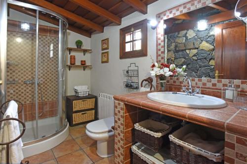 a bathroom with a sink and a shower and a toilet at Casa Maday in Villa de Mazo