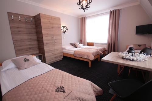 a hotel room with two beds and a window at Dom Wypoczynkowy u Czerników in Białka Tatrzanska