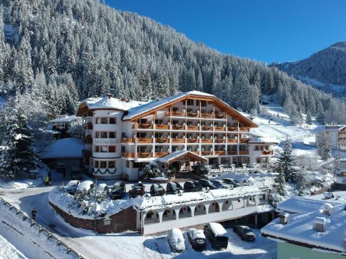 a hotel in the mountains in the snow at Hotel Cesa Tyrol in Canazei