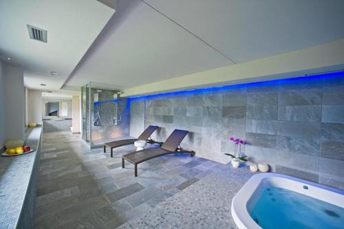a swimming pool in a room with a tub at Wine Hotel Retici Balzi in Poggiridenti