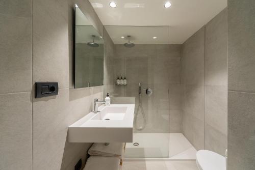 a bathroom with a sink and a toilet and a mirror at Hotel Distrito Oeste in Donostia-San Sebastián