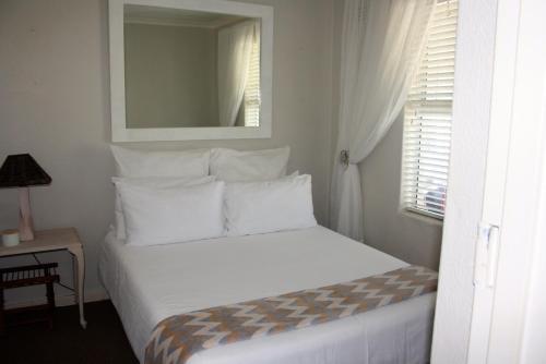 a white bed in a room with a window at 142 hermanus beach club in Hermanus