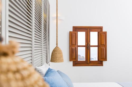 a room with a window and a swing at Lindos Del Mar Suites - Adults Only in Líndos