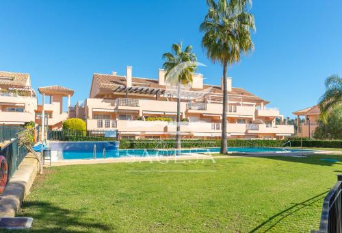 a large apartment building with a large yard in front of it at Los Jardines de Santa Maria Golf in Marbella