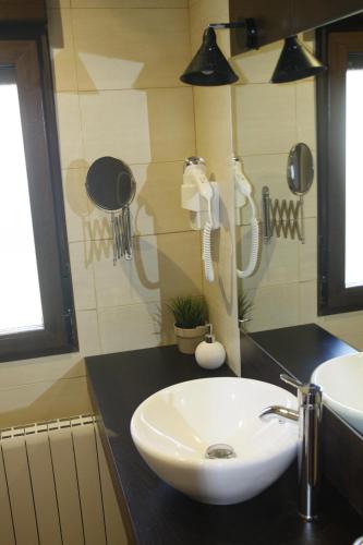 y baño con lavabo blanco y espejo. en Casa Rural Las Pegueras, en Ávila