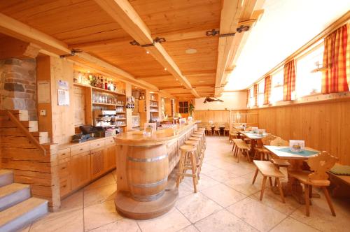 a restaurant with a barrel bar and tables and chairs at Gästehaus Waltl in Krimml