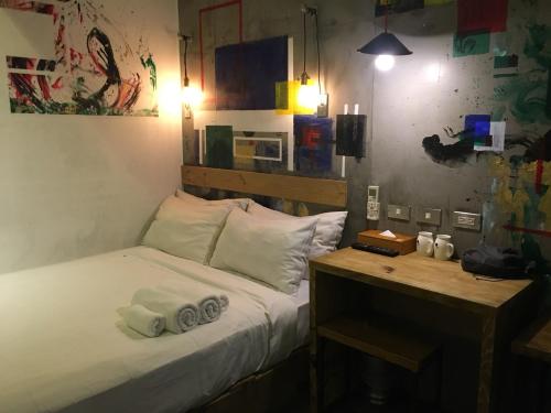 Un dormitorio con una cama y un escritorio con toallas. en Just Inn 正旅館 北車, en Taipéi
