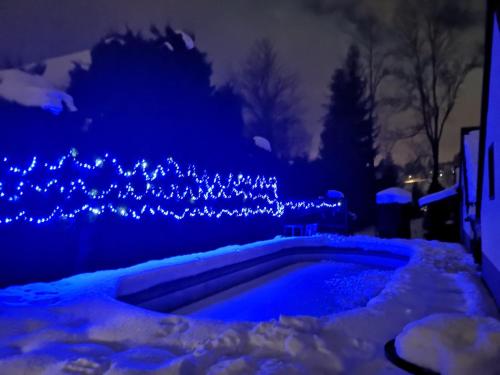 a swimming pool covered in snow with blue lights at O.W. Blue Cafe in Krościenko