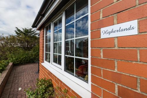 a window of a brick building with a sign on it at Higherlands in Kingsley