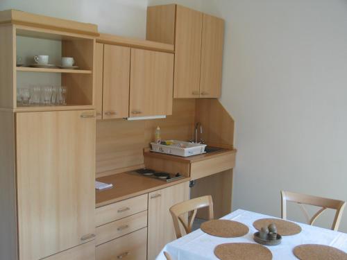 a kitchen with wooden cabinets and a table with chairs at Apartmany A.Ša Kašperské Hory in Kašperské Hory