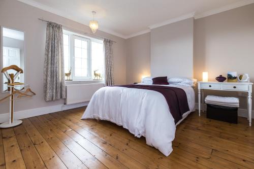 ein weißes Schlafzimmer mit einem Bett und einem Fenster in der Unterkunft Higherlands in Kingsley