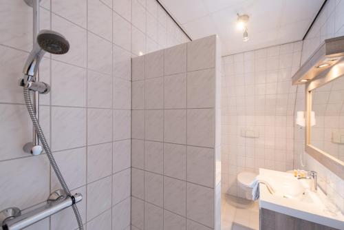 a bathroom with a shower and a sink at Hotel Nes in Nes