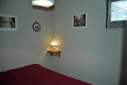 ein Schlafzimmer mit einem Bett und einer Lampe auf einem Tisch in der Unterkunft Résidence les Bords du Lac in Le Lauzet-Ubaye
