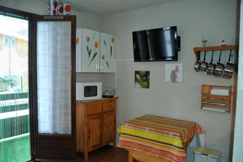 Kleines Zimmer mit einem Bett und einer Mikrowelle. in der Unterkunft Résidence les Bords du Lac in Le Lauzet-Ubaye
