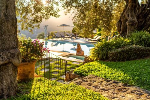 una piscina en un patio con árboles y plantas en Ca's Xorc Luxury Retreat - ADULTS ONLY, en Sóller
