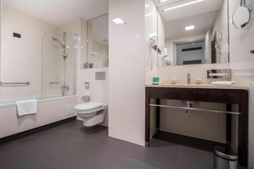 
a bathroom with a toilet a sink and a bathtub at Hotel Atrium in Split
