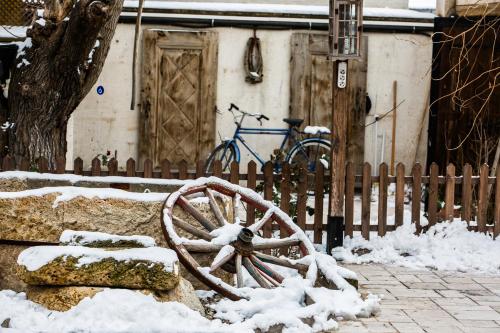 una ruota di legno ricoperta di neve accanto a una recinzione di Hikmet's House ad Avanos