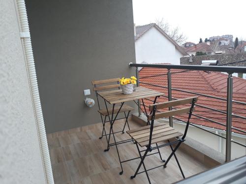 a balcony with a wooden table and chairs on it at Vila & Apartments MATEA in Gevgelija