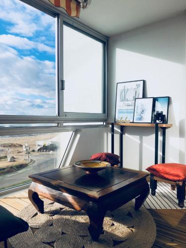 un salon avec une table et une grande fenêtre dans l'établissement STUDIO FACE MER PORNICHET – VUE BAIE DE LA BAULE, à Pornichet