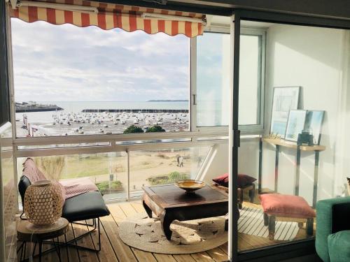 a room with a large window with a view of a beach at STUDIO FACE MER PORNICHET – VUE BAIE DE LA BAULE in Pornichet