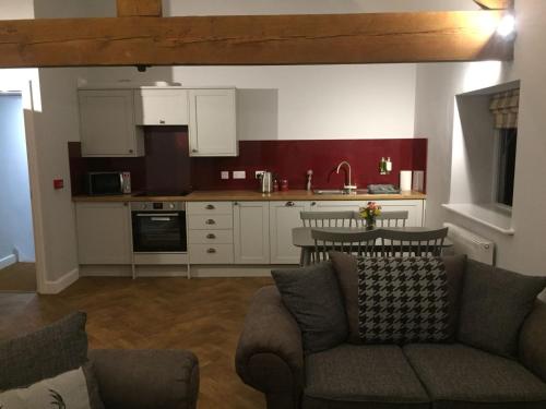 a living room with a couch and a kitchen at Rolling Mill, Wolds Way Holiday Cottages, 2 Bed, 1st floor in Cottingham