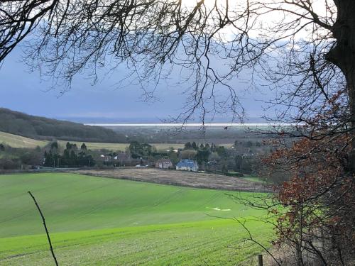 a view of a green field with the ocean in the background at Rolling Mill, Wolds Way Holiday Cottages, 2 Bed, 1st floor in Cottingham